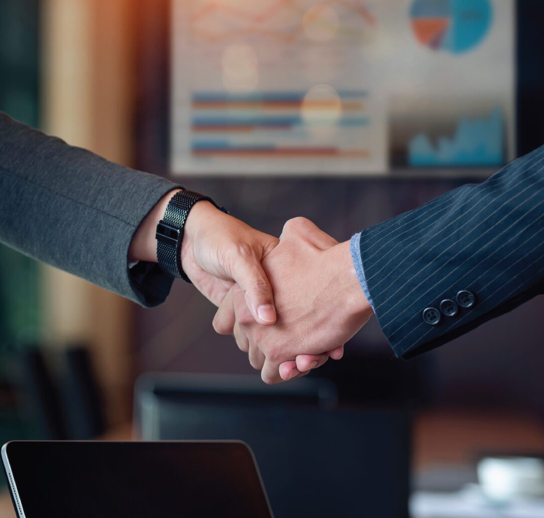  Two people engaging in a handshake over a business deal.